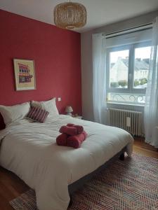 a bedroom with a large bed with a red wall at Maison Maurice Quimper in Quimper +18 photos