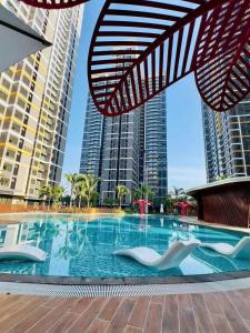 a swimming pool in the middle of some tall buildings at Bống Homestay-Luxury Apartment-Vinhomes Grand Park in Long Bình