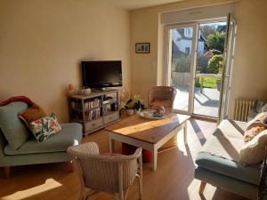 a living room with a tv and a table and chairs at Maison Maurice Quimper in Quimper