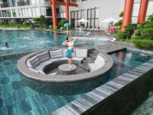 a woman standing in front of a swimming pool at Homestay Onsen Ecopack in HÆ°ng YÃªn