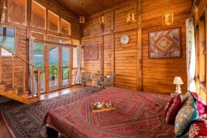 une chambre avec un lit dans une cabane en rondins dans l'établissement Stay Leisurely Woodscape 5BHK, Pawna Lake, à Malavli