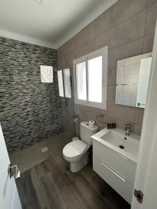 ein Badezimmer mit Toilette und Waschbecken in der Unterkunft Apartamento Empul Barrosa Beach in Novo Sancti Petri