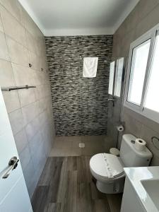ein Badezimmer mit weißer Toilette und Dusche in der Unterkunft Apartamento Empul Barrosa Beach in Novo Sancti Petri