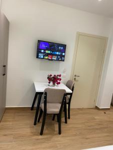 ein Esszimmer mit Tisch und Stühlen und einem Fernseher in der Unterkunft Hajdini Apartament & Studios in Sarandë