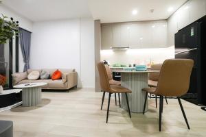 a kitchen and living room with a table and chairs at Luxury Apartment-Vinhomes Grand Park Quận 9-Plus 2PN in Gò Công