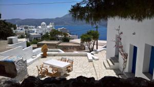 a patio with a table and chairs and the ocean at Piazza Castello in Plaka Milou