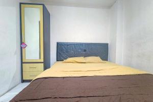 a bedroom with a bed with a blue headboard at Guest House 88 RedPartner in Jakarta