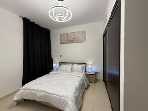 a bedroom with a large bed with a black curtain at Mangrove Place in Abu Dhabi