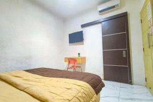a bedroom with a bed and a chair and a desk at Guest House 88 RedPartner in Jakarta