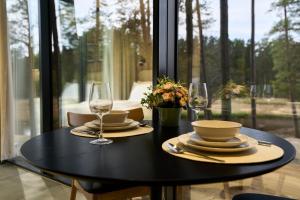 a black table with plates and glasses on it at Bejas Lux Mirror Houses in Stūri