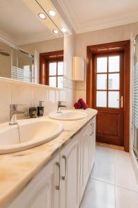 Un baño con dos lavabos y un espejo grande. en Villa privada con jardín,2 dormitorios, en Playa Blanca