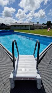 un banco blanco sentado junto a una piscina en Domki letniskowe Ranczo, en Darłowo
