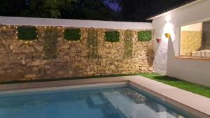 un cortile con una parete in pietra e una piscina di RaíZes 22 - Apartamento 5 a Puebla de Don Fadrique
