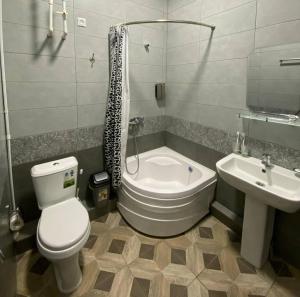 a bathroom with a toilet and a tub and a sink at Elite Boutique in Samarkand