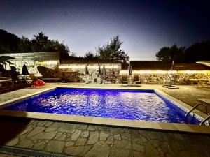 a swimming pool with blue water in a backyard at Apartmani Gocki Raj 2024 Vrnjačka Banja in Vrnjačka Banja