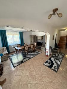 a living room with a table and a dining room at Pensiunea Diana in Novaci