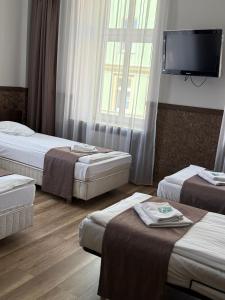 a hotel room with three beds and a flat screen tv at Dolnośląski in Ząbkowice Śląskie +30 photos