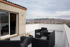 a balcony with chairs and a table on a building at Hotel Vigo Plaza in Vigo