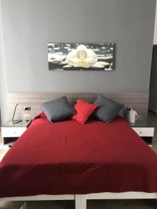 ein Schlafzimmer mit einem roten Bett mit einer weißen Blume an der Wand in der Unterkunft La Dimora di Garibaldi in Neapel