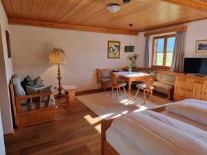 a bedroom with a bed and a dining room with a table at Menkenhof in Reit im Winkl
