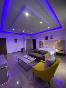 a hotel room with a bed and a couch and a table at Marchforte Courtyard Hotel & Suites in Ibadan