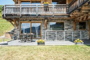 a house with a deck and a table and chairs at Studio De Charme Montagne in Notre-Dame-du-Pré