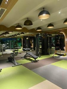 a woman is walking in a gym with machines at Bống Homestay-Luxury Apartment-Vinhomes Grand Park Quận 9 in Gò Công
