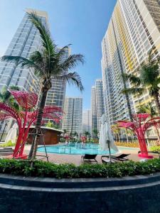 a pool in a city with palm trees and buildings at Bống Homestay-Luxury Apartment-Vinhomes Grand Park Quận 9 in Gò Công