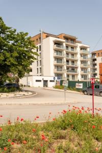 an empty street in front of a large apartment building at 1-Bedroom LUX Apartment with Balcony & Underground Parking Garage in Spišská Nová Ves