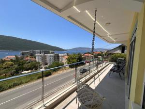 a balcony with a hammock and a view of a road at Deluxe Apartment 2-rooms in Herceg-Novi