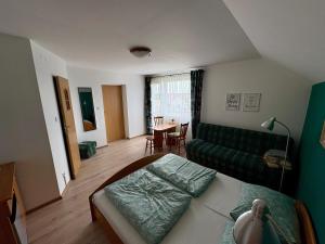 a living room with a green couch and a table at Pokoje gościnne SARA in Ostrowo