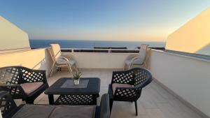 a balcony with tables and chairs and the ocean at Sea&Sun Living in Ulcinj
