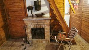 a living room with a fireplace and a chair at Chatka Cicho-Sza in Lanckorona