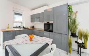 a kitchen with a table and white chairs at 3 Bedroom Beautiful Home In Maslenica in Maslenica