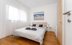 a white bedroom with a bed and a window at 3 Bedroom Beautiful Home In Maslenica in Maslenica