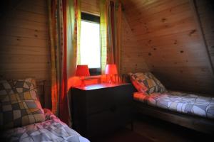 a room with two beds and a table with a lamp at Domek nad Solinką in Bukowiec