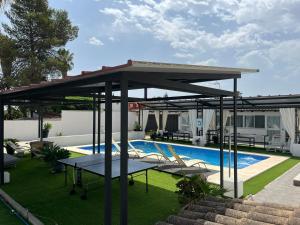 pawilon ze stołem i krzesłami przy basenie w obiekcie Apartamento 2, Chalet Manzano a 15" de Sevilla, a 30" del Aeropuerto de Sevilla w mieście Villanueva del Ariscal +15 zdjęć