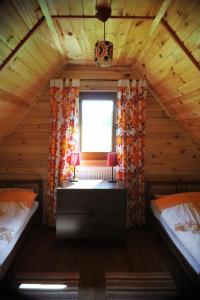 a bedroom with two beds and a window in a cabin at Domek nad Solinką in Bukowiec
