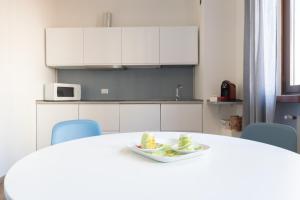 a white kitchen with a table with a plate of food on it at appartamento centralissimo vista terme in Vittorio Veneto