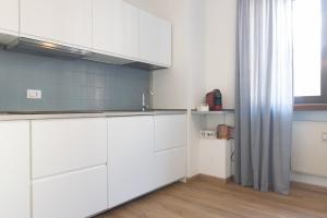 a kitchen with white cabinets and a sink at appartamento centralissimo vista terme in Vittorio Veneto