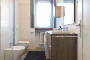 a bathroom with a sink and a toilet and a window at appartamento centralissimo vista terme in Vittorio Veneto