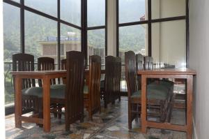 a dining room with a table and chairs and a window at Shivlinga Tourist Complex in Uttarkāshi