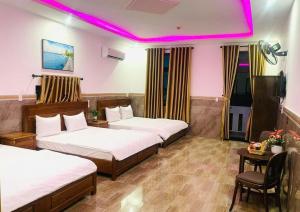 a hotel room with two beds and a purple lighting at Thảo Vân 3 Hotel in Danang