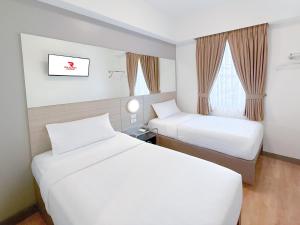 una camera d'albergo con due letti e una finestra di Red Planet Makati Amorsolo a Manila