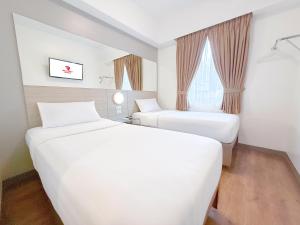 una camera d'albergo con due letti e una finestra di Red Planet Makati Amorsolo a Manila