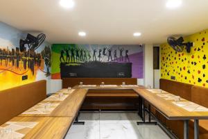 a dining room with a long table and a mural at Hotel Money Plant in Jogeshwāri