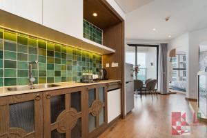 une cuisine avec un évier et du carrelage vert au mur dans l'établissement Apec Mandala Mui Ne by LHG - Sea View, Infinity Pool, 17m to Bàu Trắng Bình Thuận, à Mui Ne