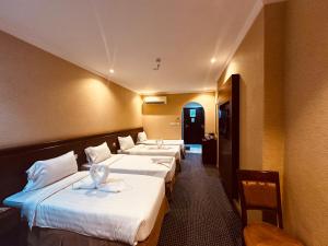 a row of four beds in a hotel room at Diouf Al-Mquam Al-Masy Hotel shuttle service to the Haram in Mecca