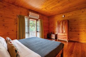 a bedroom with a bed and a window in a cabin at Senaro Farms in Varagampadi +62 photos