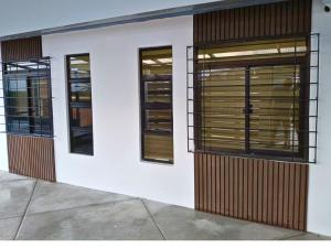 a white building with three windows on it at YBonita in Sampong
